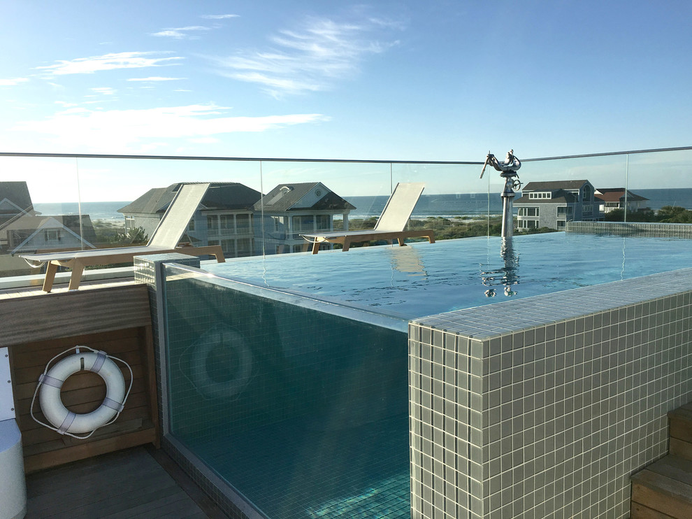 This is an example of a contemporary rooftop rectangular infinity pool in Other with decking.