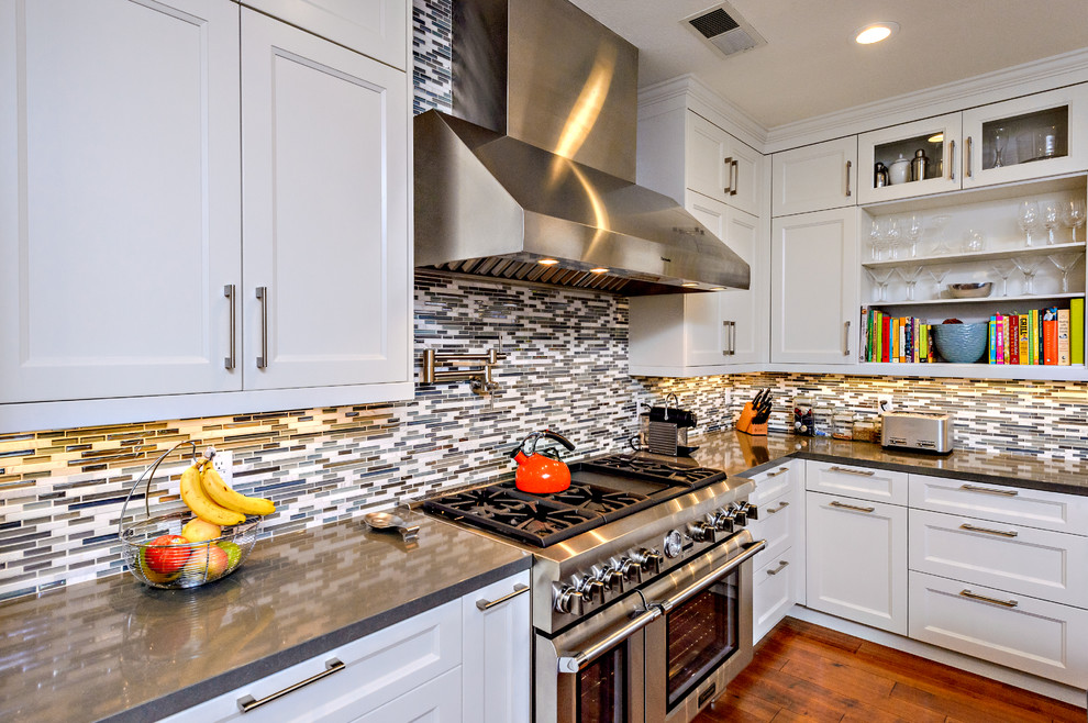 Inspiration for a transitional u-shaped kitchen remodel in San Diego with quartz countertops, multicolored backsplash, matchstick tile backsplash, stainless steel appliances, recessed-panel cabinets and white cabinets