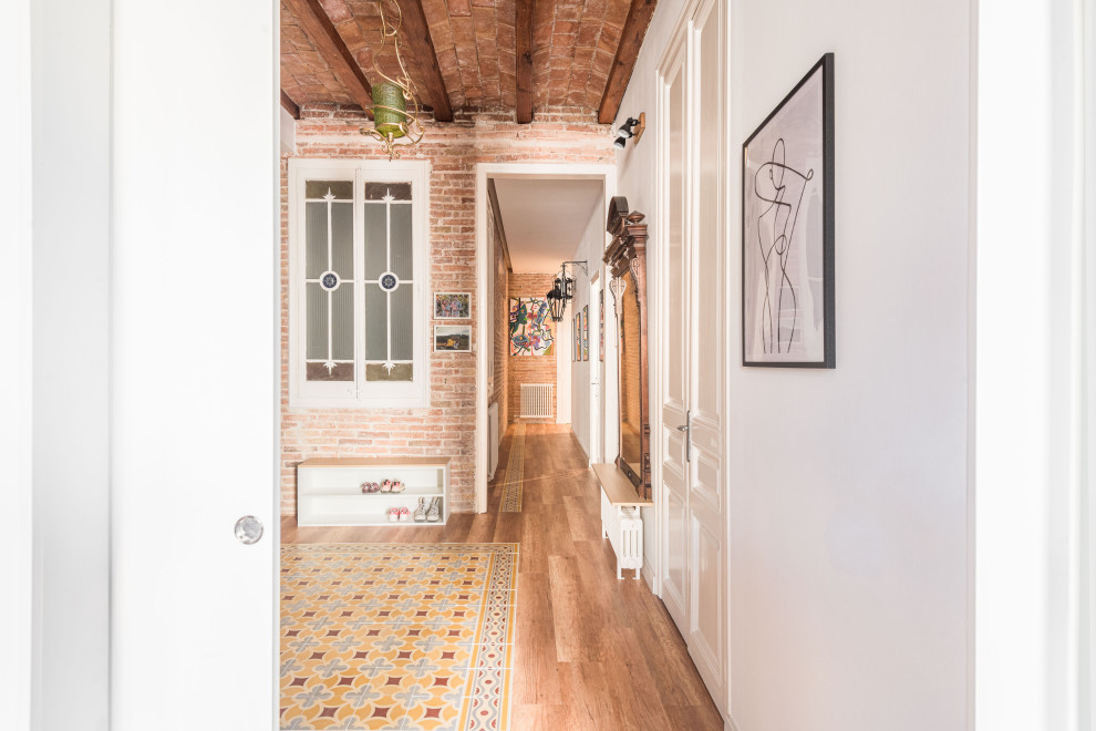 Hallway - mid-sized transitional vinyl floor, multicolored floor, exposed beam and brick wall hallway idea in Barcelona with white walls
