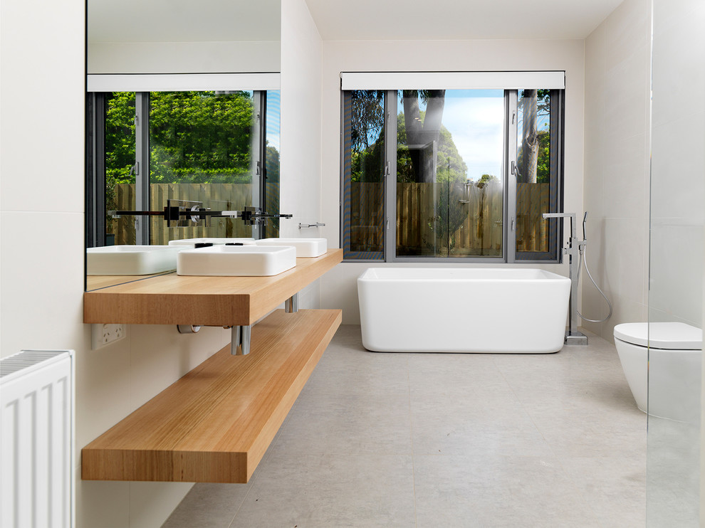 Photo of a contemporary bathroom in Melbourne with a freestanding tub and concrete floors.