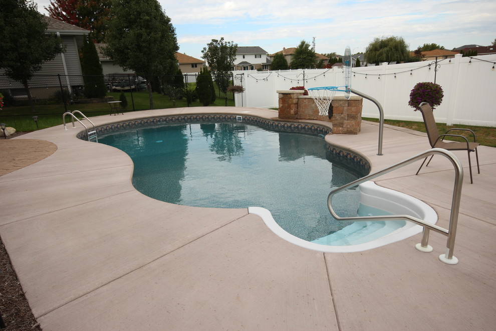 This is an example of a small mediterranean backyard custom-shaped pool in Chicago with stamped concrete.