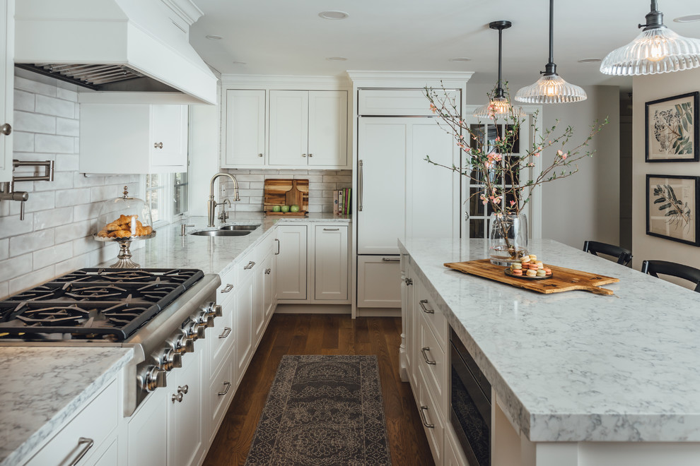 This is an example of a traditional kitchen in Boston with white cabinets and quartz benchtops.