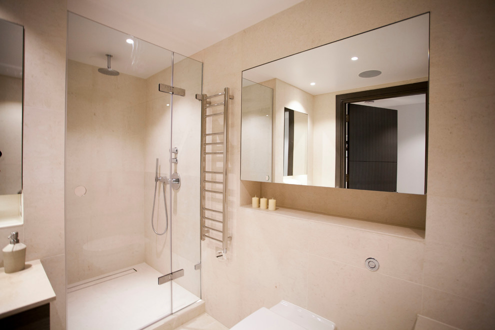 Design ideas for a mid-sized contemporary 3/4 bathroom in London with a drop-in sink, glass-front cabinets, dark wood cabinets, limestone benchtops, an open shower, a wall-mount toilet, beige tile, beige walls and limestone floors.