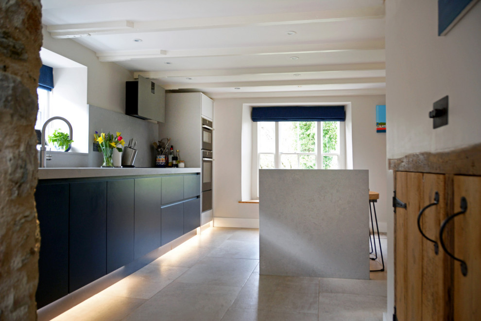 Inspiration for a small contemporary kitchen in Cornwall with flat-panel cabinets, quartz worktops, an island and grey worktops.