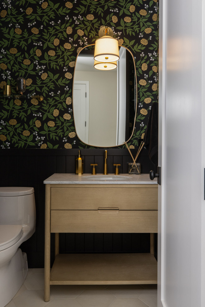 This is an example of a small country powder room in San Francisco with flat-panel cabinets, light wood cabinets, a one-piece toilet, black walls, ceramic floors, an undermount sink, marble benchtops, grey floor, grey benchtops, a freestanding vanity and decorative wall panelling.