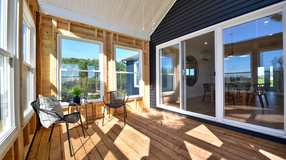Foto di una veranda stile marino di medie dimensioni con pavimento in legno massello medio, lucernario e pavimento marrone