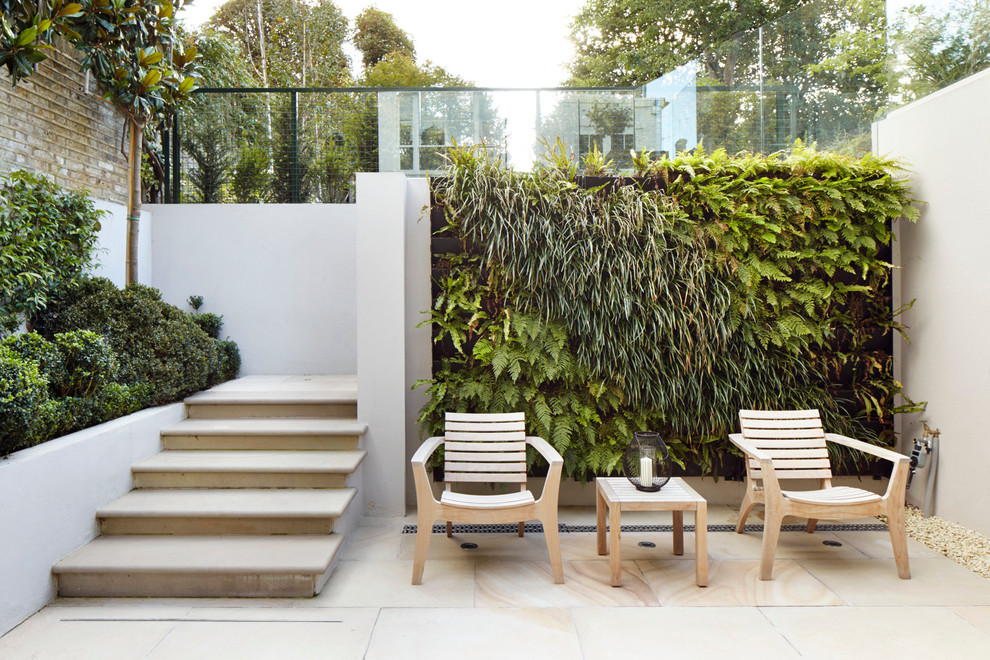 Photo of a contemporary patio in London with a vertical garden.
