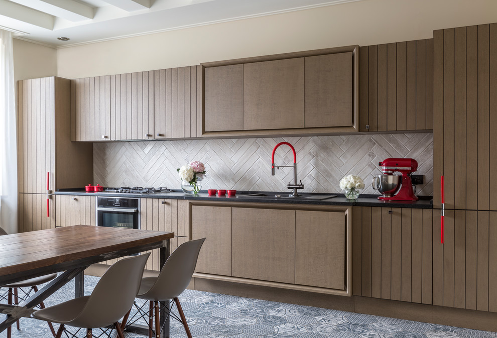 This is an example of a mid-sized contemporary single-wall open plan kitchen in Moscow with a drop-in sink, flat-panel cabinets, brown cabinets, grey splashback, black appliances, no island and multi-coloured floor.