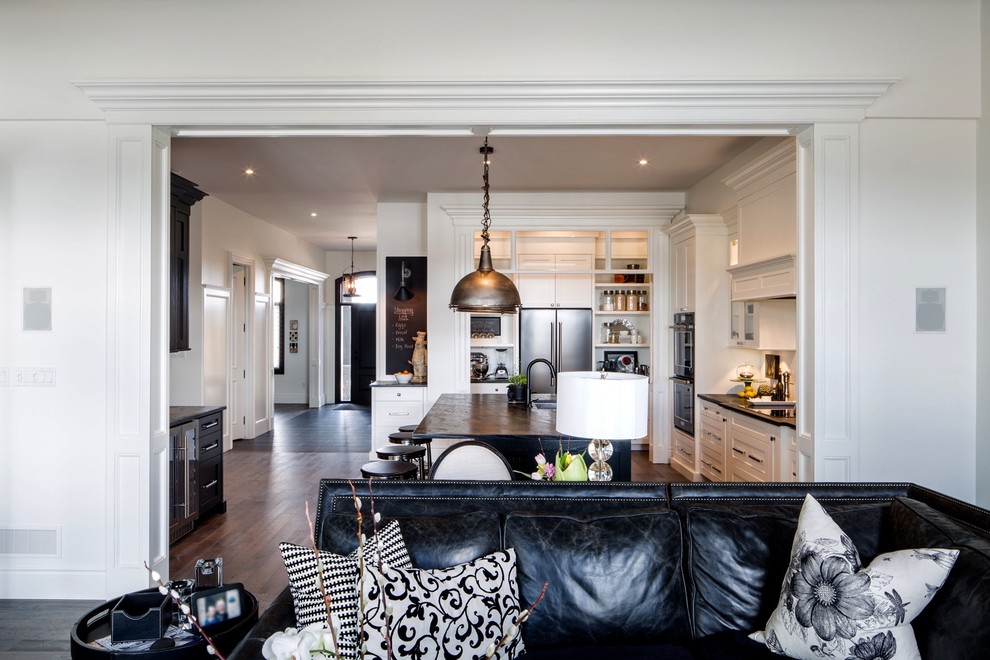 Inspiration for a large transitional galley medium tone wood floor and brown floor open concept kitchen remodel with an undermount sink, shaker cabinets, white cabinets, granite countertops, white backsplash, stainless steel appliances and an island