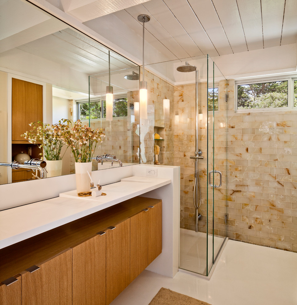 Photo of a midcentury bathroom in San Francisco with flat-panel cabinets, medium wood cabinets, a corner shower, beige tile, subway tile and an integrated sink.