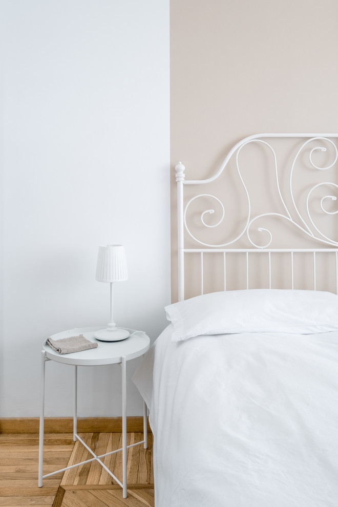 Photo of a small contemporary guest bedroom in Rome with white walls, light hardwood floors and beige floor.