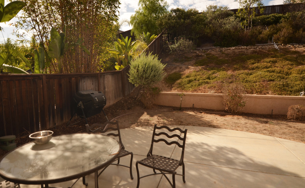 This is an example of a small modern backyard partial sun xeriscape for summer in San Diego with with fireplace and gravel.
