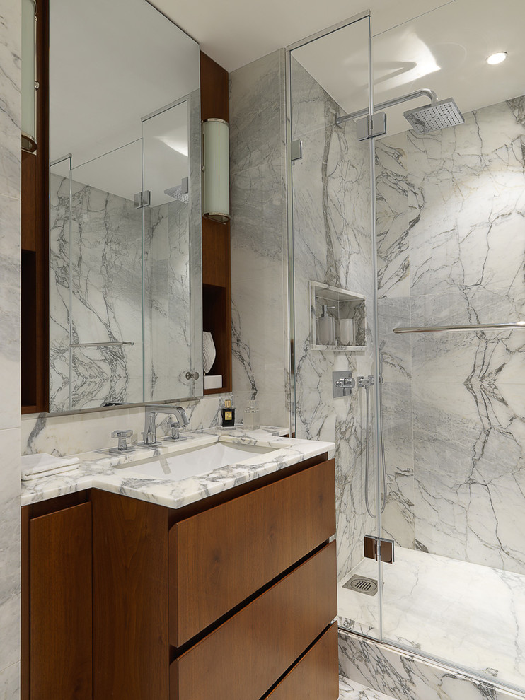 Design ideas for a contemporary 3/4 bathroom in London with flat-panel cabinets, medium wood cabinets, gray tile, white tile, an undermount sink, a hinged shower door, an alcove shower, stone slab and multi-coloured benchtops.