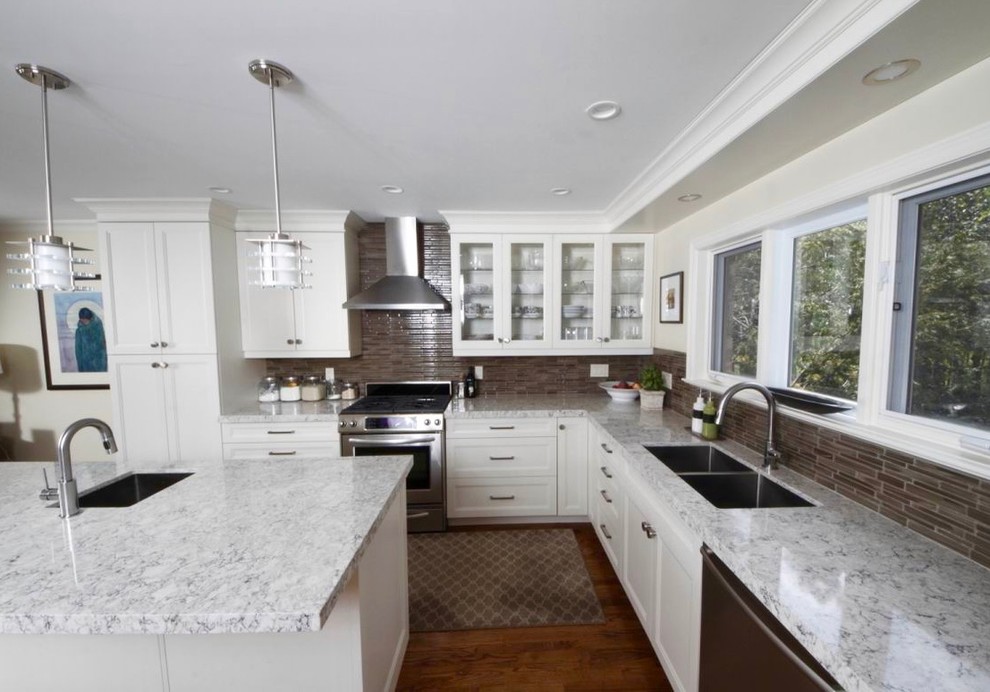 This is an example of an expansive modern l-shaped eat-in kitchen in Toronto with an undermount sink, glass-front cabinets, white cabinets, quartz benchtops, grey splashback, glass tile splashback, stainless steel appliances, medium hardwood floors and with island.