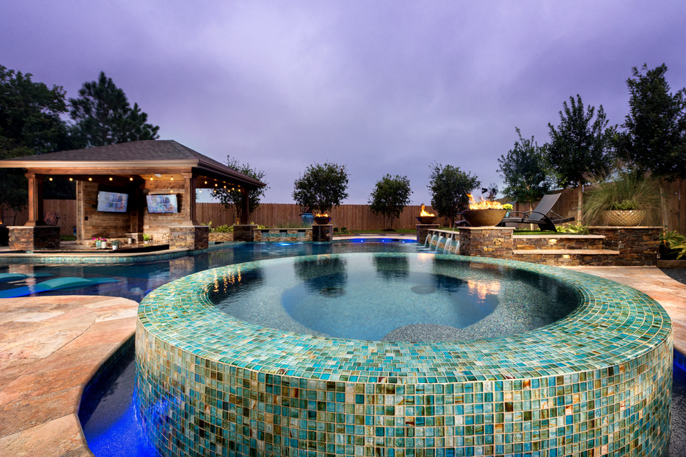 This is an example of a large modern backyard custom-shaped pool in Houston with tile.