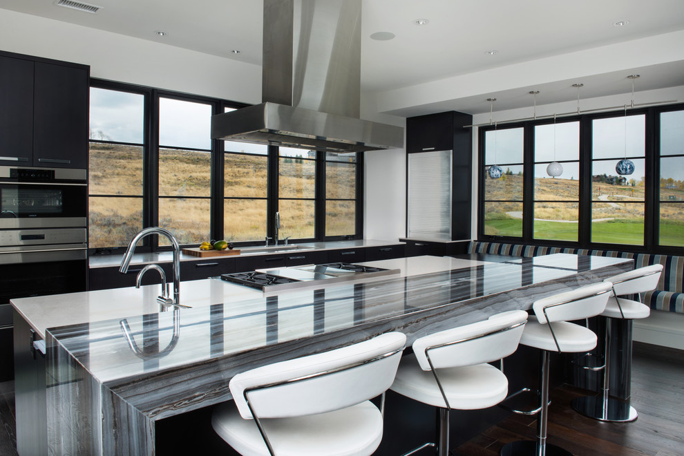 Inspiration for a large contemporary eat-in kitchen in Denver with flat-panel cabinets, black cabinets, marble benchtops, with island, an undermount sink, stainless steel appliances, dark hardwood floors, brown floor and grey benchtop.