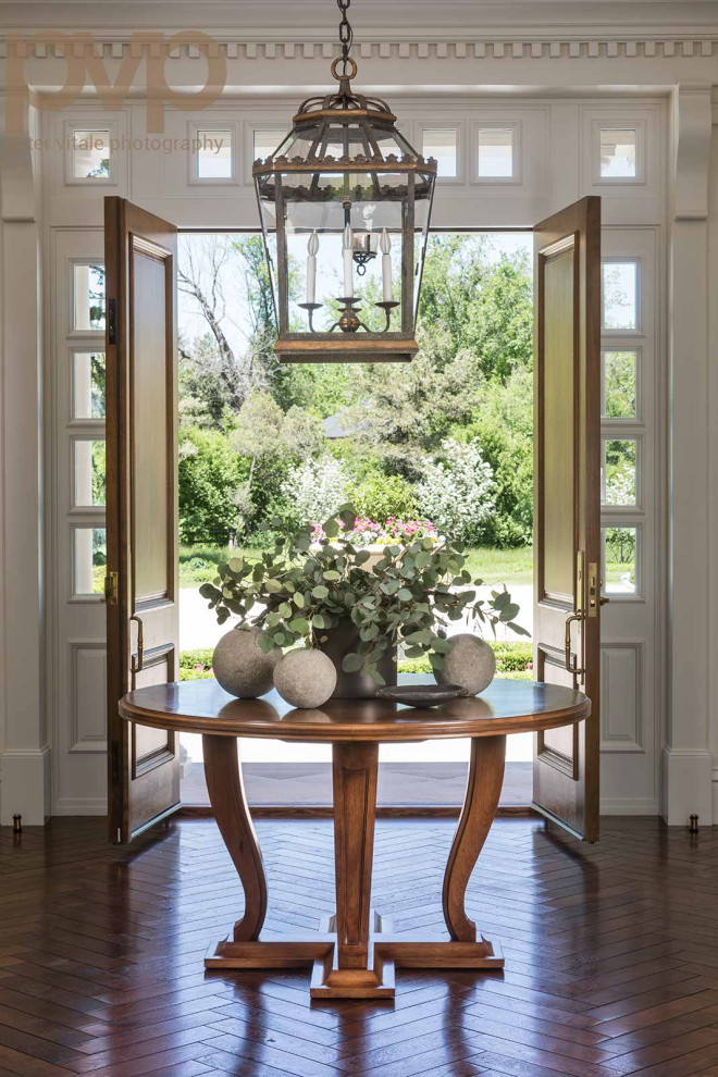 Medium tone wood floor and brown floor foyer photo in Denver with a medium wood front door