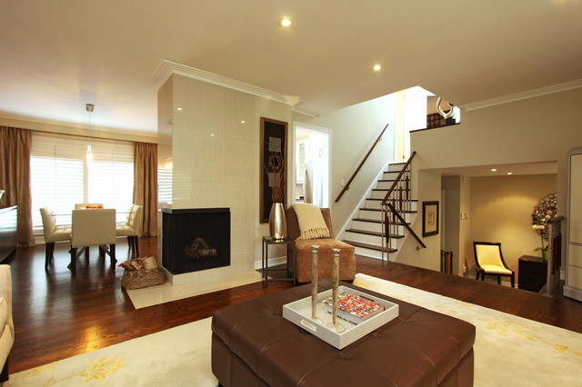 Inspiration for a large contemporary open concept living room in Toronto with a corner fireplace, a tile fireplace surround, beige walls, medium hardwood floors and a concealed tv.