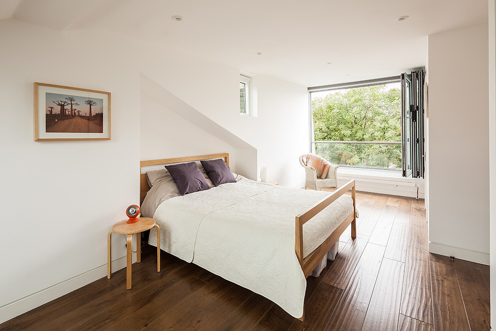 Photo of a small contemporary master bedroom in London with white walls and medium hardwood floors.