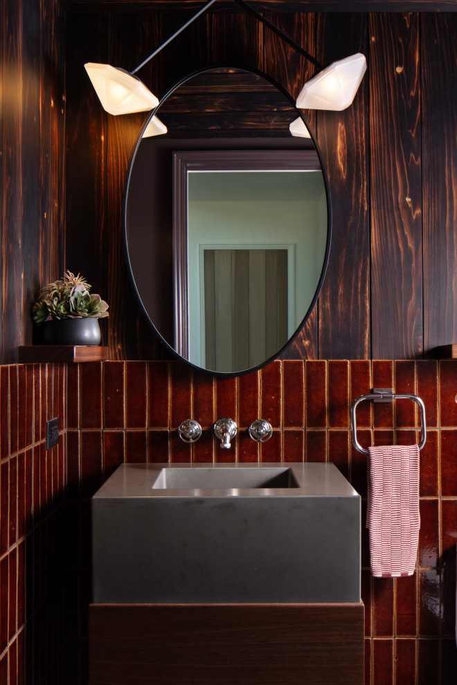 Idéer för ett lantligt grå toalett, med släta luckor, skåp i mellenmörkt trä, röd kakel, bruna väggar och ett integrerad handfat