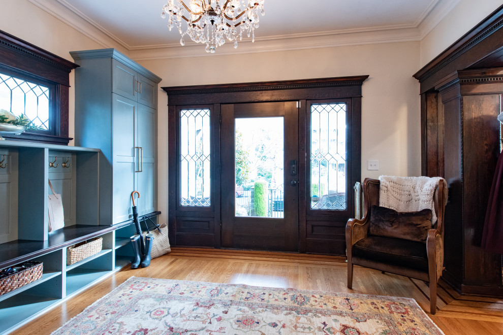 Photo of a small traditional foyer in Seattle with white walls, light hardwood floors, a single front door, a brown front door and brown floor.