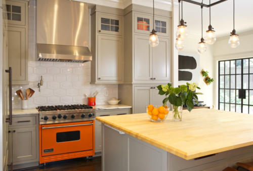 Full kitchen view with wood counter tops and orange stove