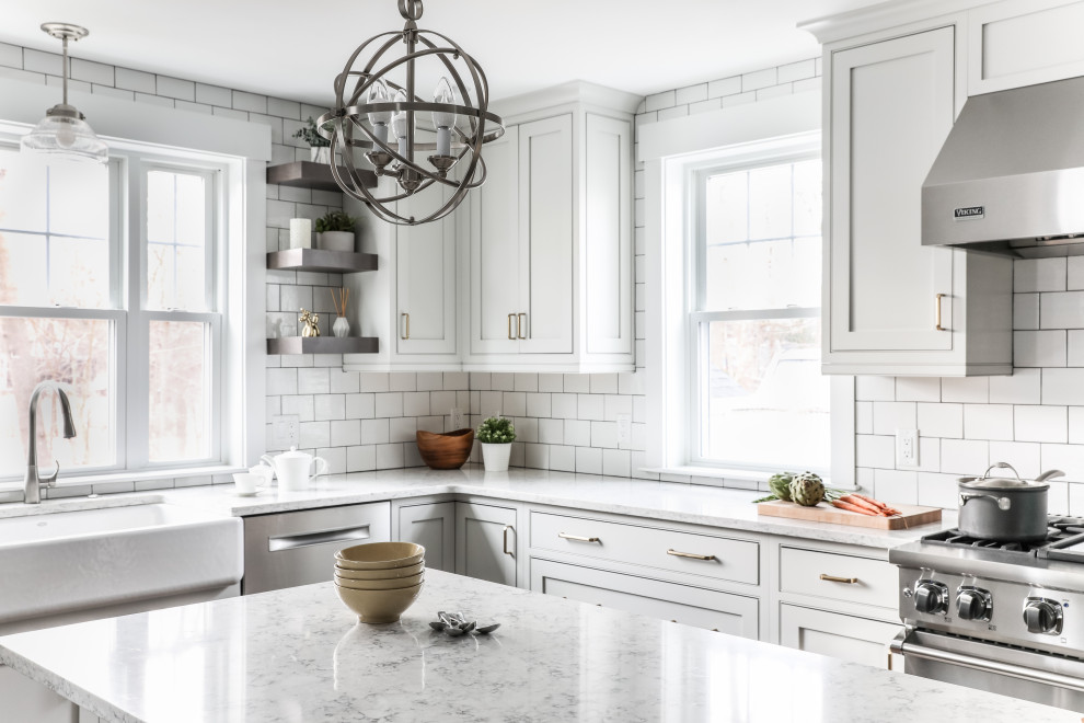 Eat-in kitchen - transitional l-shaped medium tone wood floor and brown floor eat-in kitchen idea in Boston with a farmhouse sink, beaded inset cabinets, white cabinets, quartz countertops, white backsplash, subway tile backsplash, stainless steel appliances, an island and gray countertops