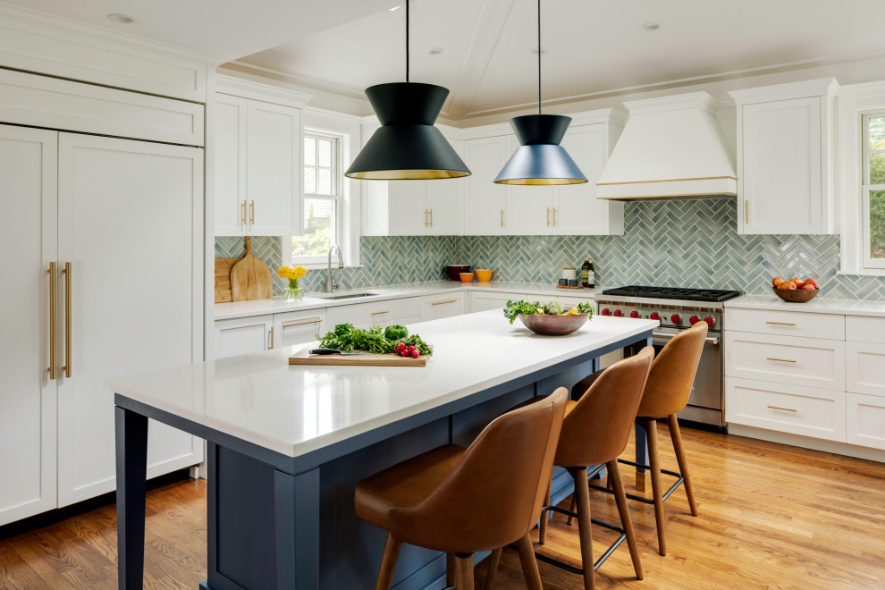 Photo of a mid-sized transitional u-shaped separate kitchen in Boston with recessed-panel cabinets, white cabinets, quartzite benchtops, blue splashback, glass tile splashback, stainless steel appliances, medium hardwood floors, with island, vaulted, an undermount sink and brown floor.