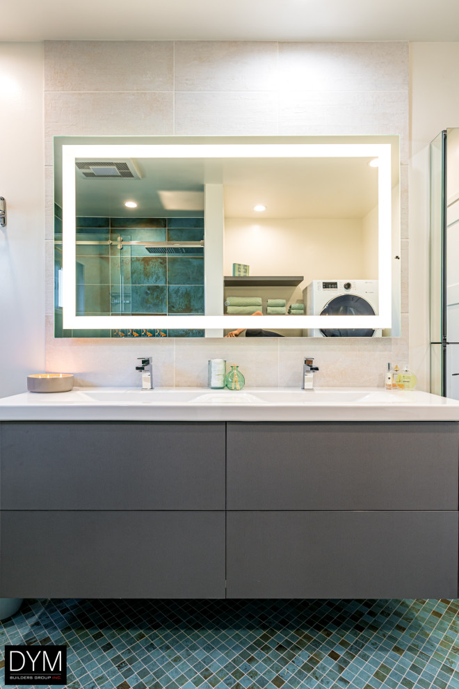 Photo of a large contemporary master bathroom in Los Angeles with flat-panel cabinets, grey cabinets, an alcove shower, a one-piece toilet, white tile, marble, white walls, mosaic tile floors, a drop-in sink, solid surface benchtops, blue floor, a hinged shower door, white benchtops, a laundry, a double vanity, a built-in vanity, wallpaper and wallpaper.