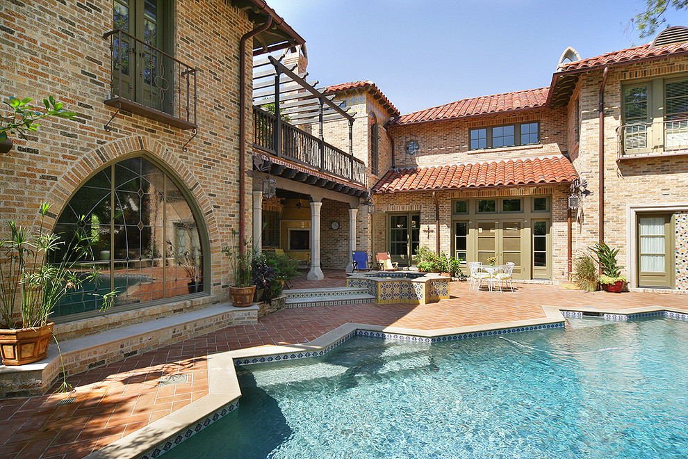 Design ideas for a mediterranean courtyard custom-shaped pool in Dallas with brick pavers.
