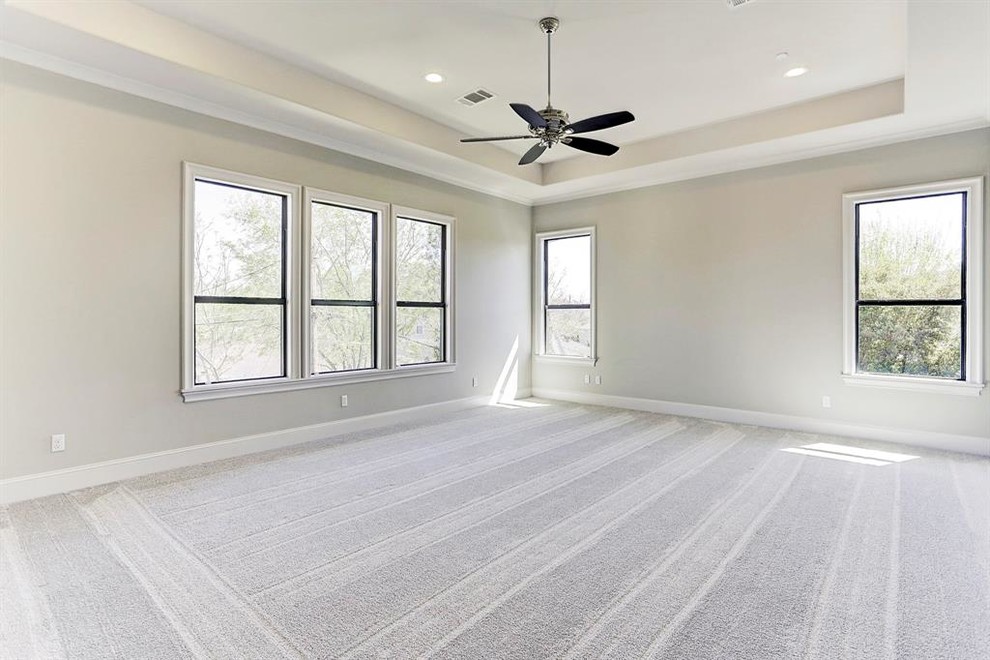 This is an example of a large contemporary master bedroom in Houston with grey walls, carpet and grey floor.