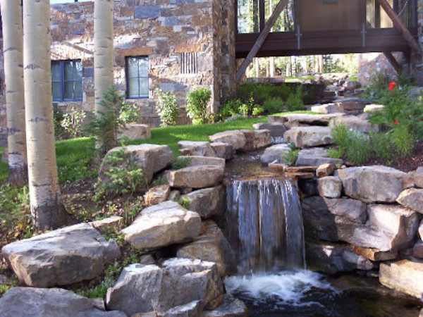 Design ideas for a huge rustic full sun backyard stone water fountain landscape in Denver.