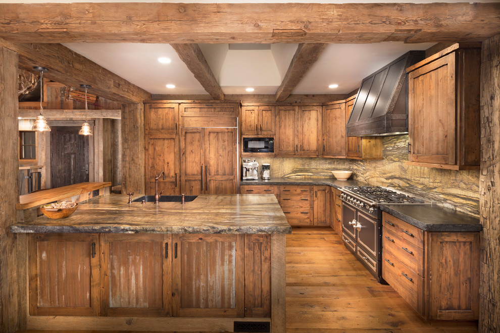 This is an example of a mid-sized country l-shaped eat-in kitchen in Sacramento with a farmhouse sink, distressed cabinets, medium hardwood floors, with island, recessed-panel cabinets, granite benchtops, multi-coloured splashback, stone slab splashback and panelled appliances.