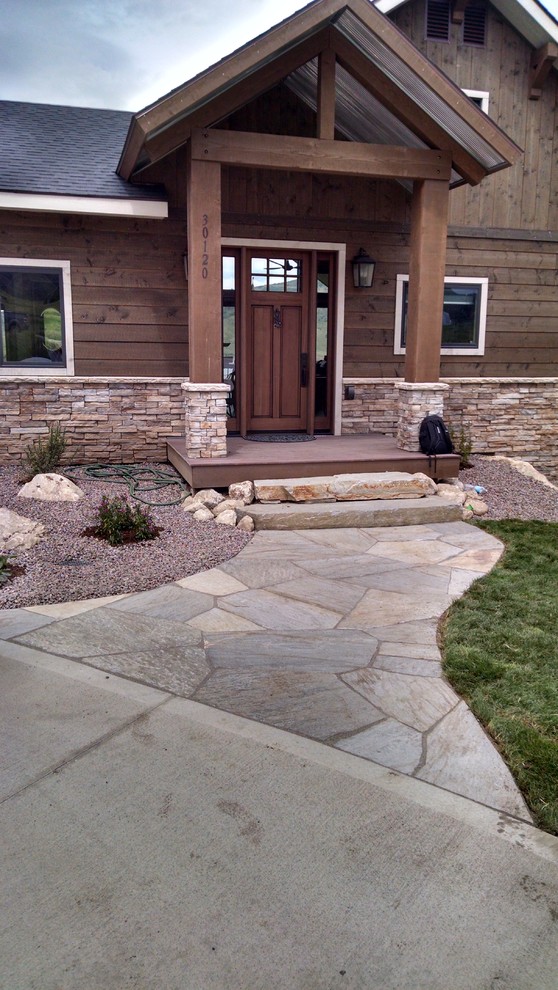 Photo of a large modern front yard full sun driveway in Denver with a garden path and natural stone pavers.