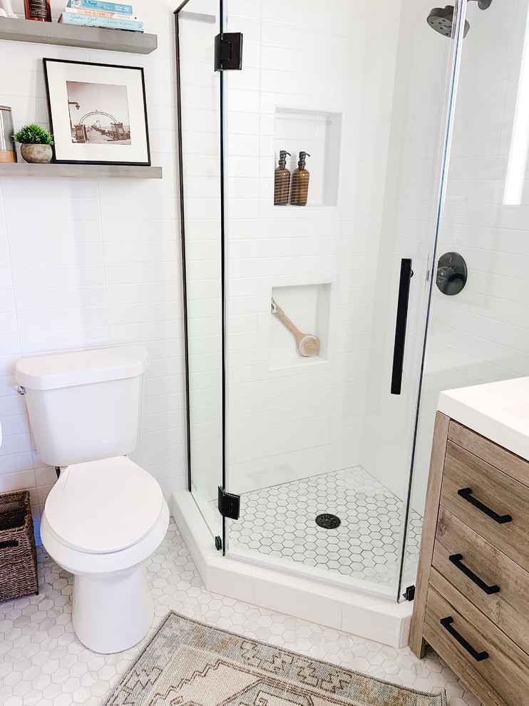 Design ideas for a small modern master bathroom in Dallas with flat-panel cabinets, light wood cabinets, a corner shower, a one-piece toilet, white tile, subway tile, white walls, porcelain floors, a drop-in sink, marble benchtops, grey floor, a hinged shower door and white benchtops.