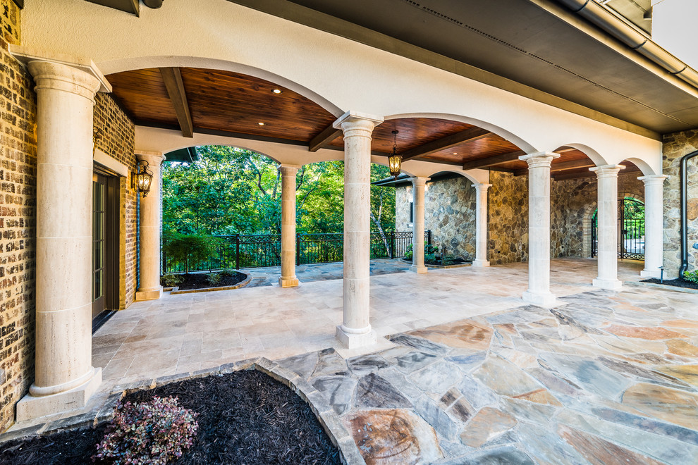 Mid-sized mountain style travertine floor and beige floor foyer photo with brown walls and a glass front door