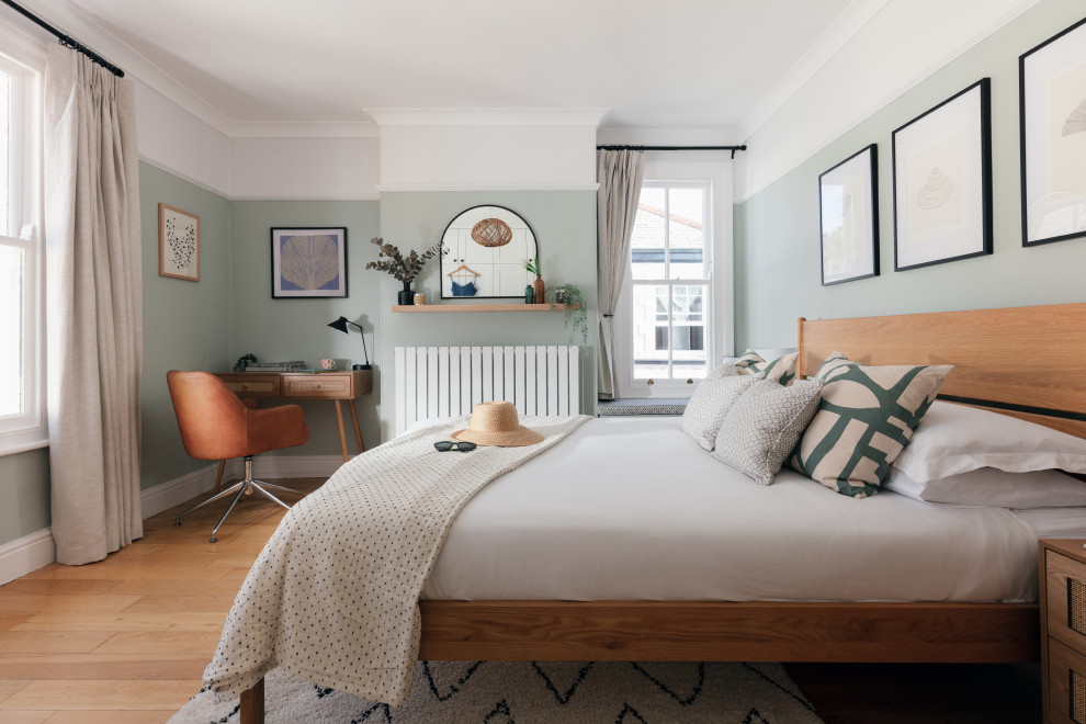 Стильный дизайн: хозяйская спальня среднего размера в скандинавском стиле с зелеными стенами, паркетным полом среднего тона и коричневым полом без камина - последний тренд