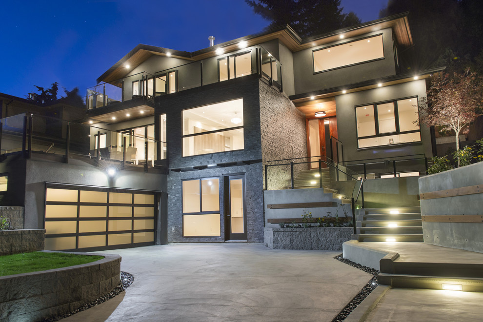 Photo of a large modern three-storey grey exterior in Vancouver with stone veneer.