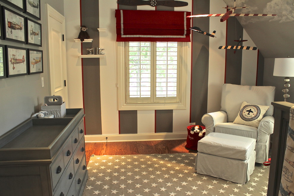 This is an example of a small transitional nursery for boys in Chicago with grey walls and medium hardwood floors.