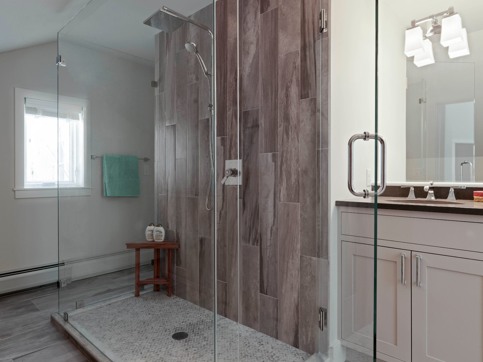Example of a mid-sized transitional 3/4 gray tile and porcelain tile porcelain tile bathroom design in Burlington with shaker cabinets, gray cabinets, a two-piece toilet, white walls, a drop-in sink and quartz countertops