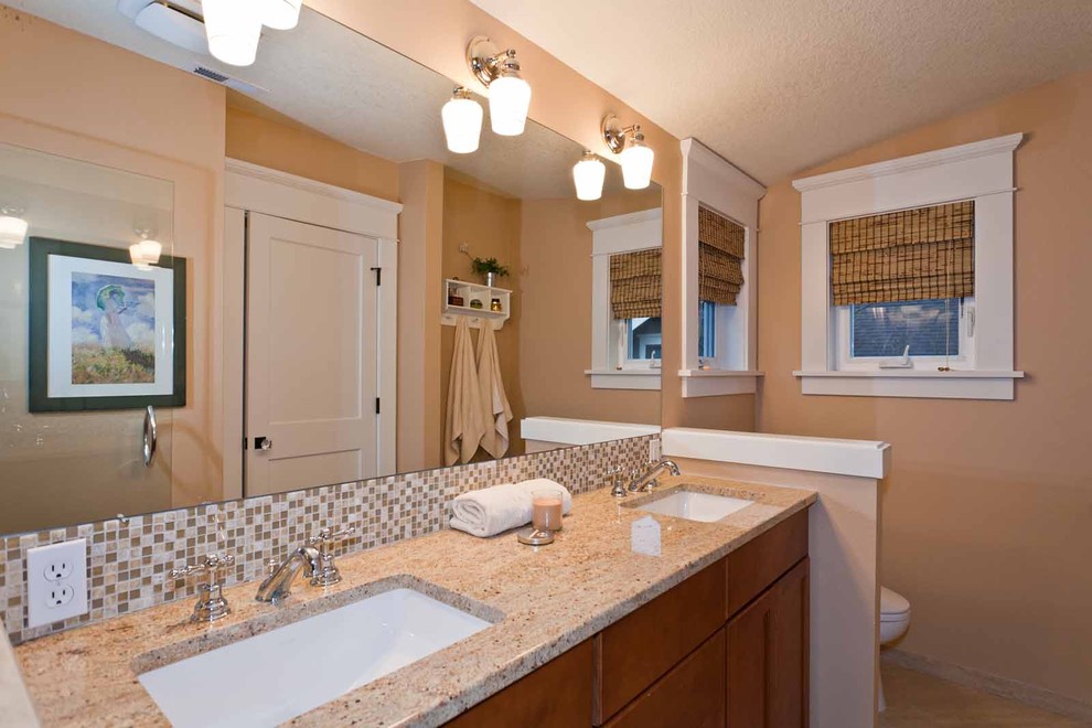 This is an example of a mid-sized arts and crafts master wet room bathroom in Portland with flat-panel cabinets, orange cabinets, a one-piece toilet, orange walls, an undermount sink, granite benchtops and a hinged shower door.