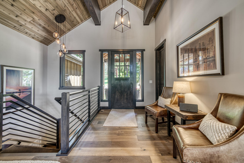 Inspiration for a country entryway in Boise with grey walls, medium hardwood floors, a single front door, a dark wood front door, brown floor and exposed beam.