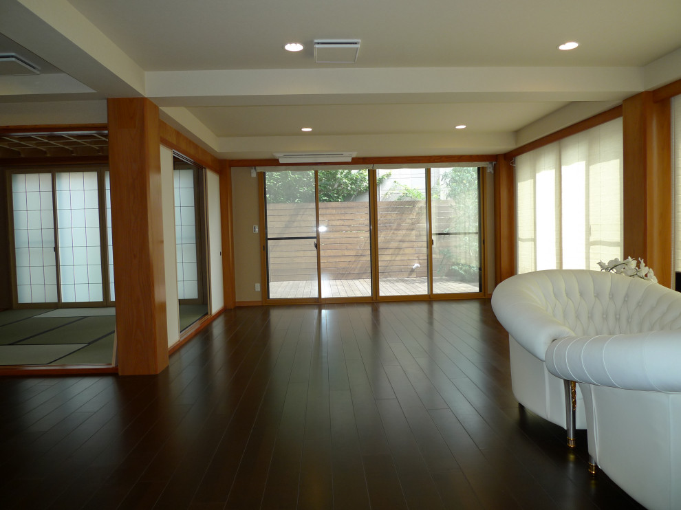 Large eclectic open concept living room in Tokyo with beige walls, plywood floors, brown floor, wallpaper and wallpaper.