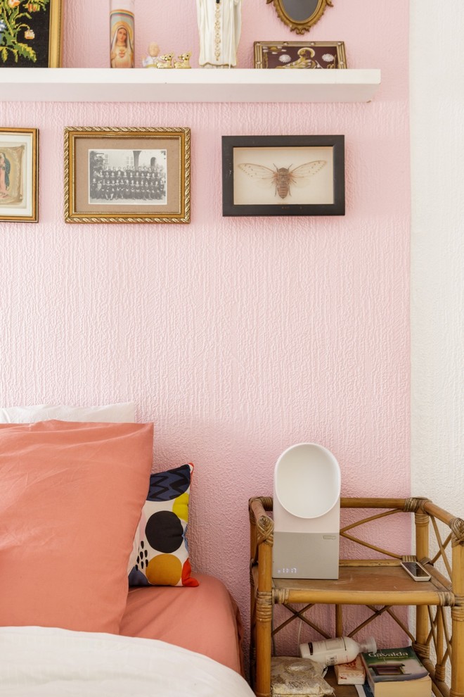Small eclectic master bedroom in Lyon with pink walls, carpet, no fireplace and grey floor.