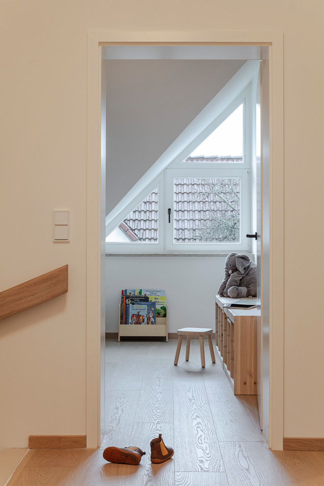 Cette photo montre une petite chambre d'enfant de 1 à 3 ans scandinave avec un mur beige, parquet clair et un sol beige.