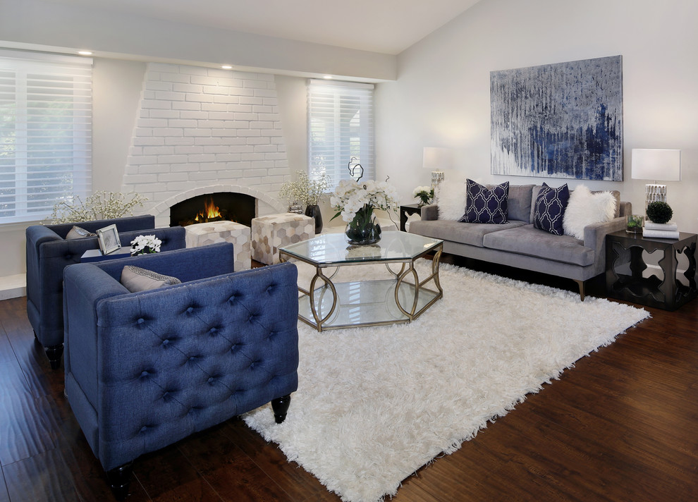This is an example of a mid-sized contemporary formal loft-style living room in Orange County with white walls, dark hardwood floors, a standard fireplace, a brick fireplace surround, no tv and brown floor.