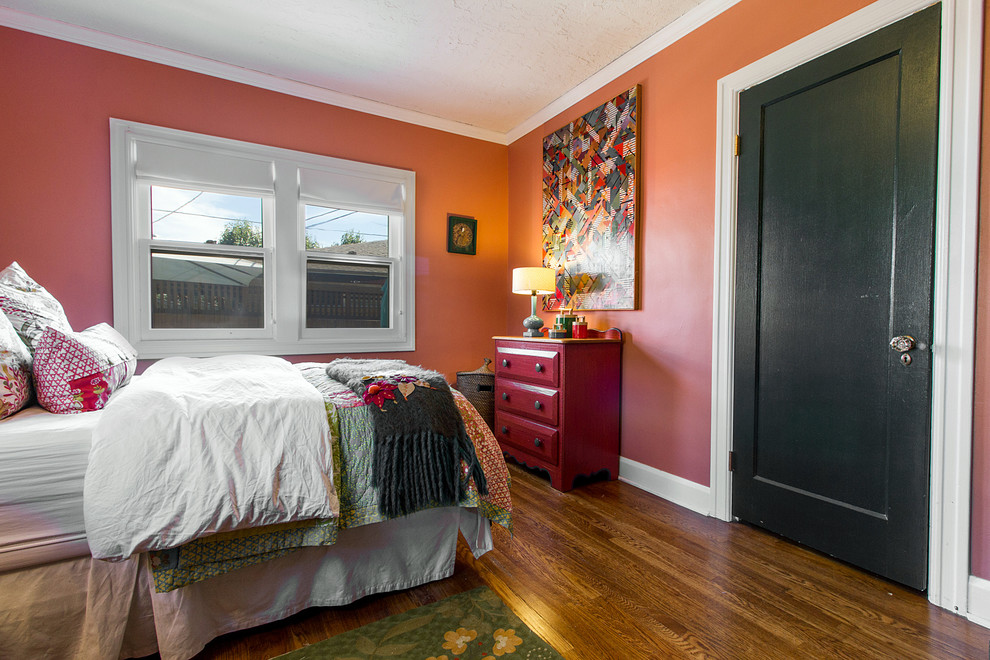 Photo of a mid-sized eclectic master bedroom in Salt Lake City with medium hardwood floors and pink walls.