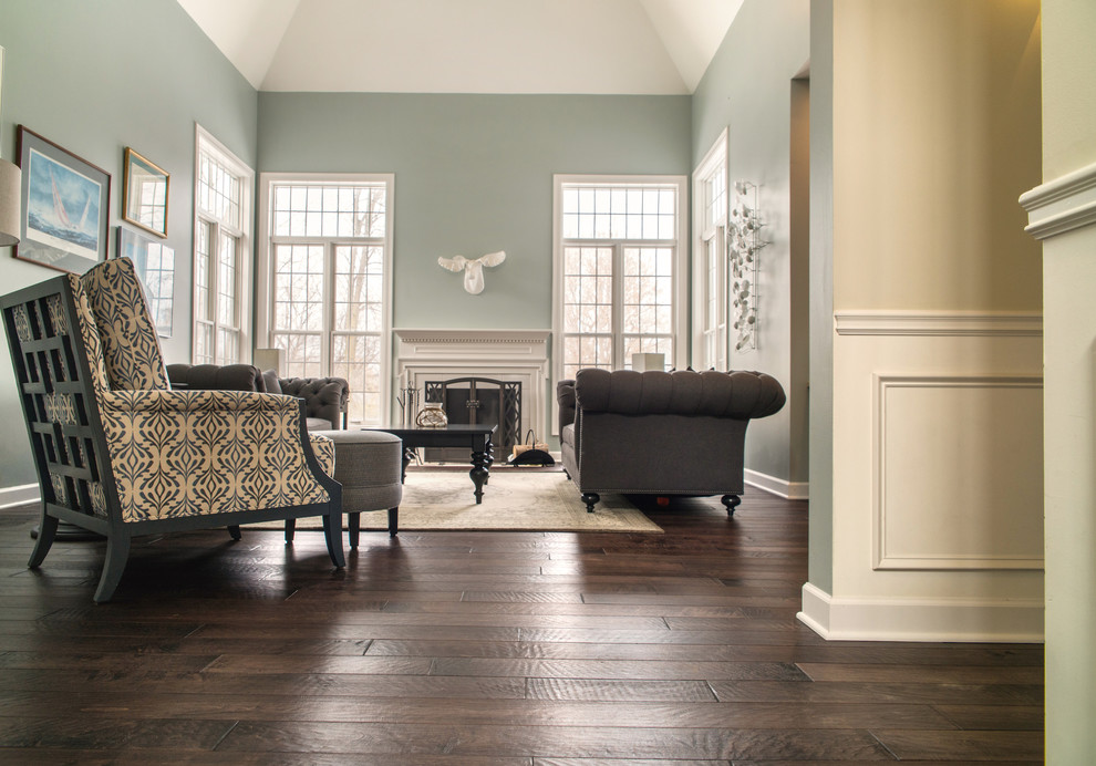 Mid-sized traditional enclosed living room in Boston with dark hardwood floors, blue walls, a standard fireplace, a stone fireplace surround and brown floor.