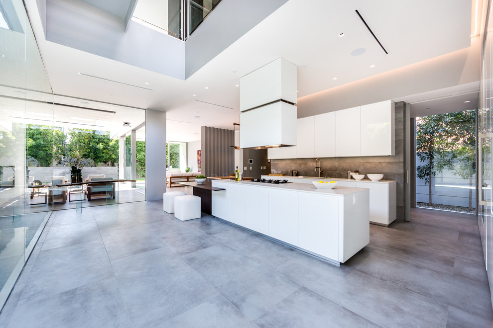 Inspiration for an expansive contemporary l-shaped open plan kitchen in Paris with a single-bowl sink, quartzite benchtops, grey splashback, stone tile splashback, black appliances, ceramic floors, with island and grey floor.