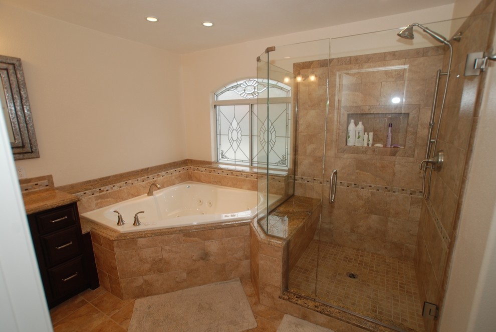 Design ideas for an expansive traditional master bathroom in Orange County with an undermount sink, raised-panel cabinets, dark wood cabinets, granite benchtops, a corner tub, a corner shower, a two-piece toilet, brown tile, porcelain tile, white walls and porcelain floors.